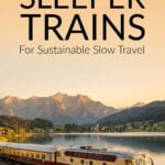 Sleeper train running alongside a lake in the sunset
