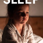Young girl sitting in bed struggling to sleep