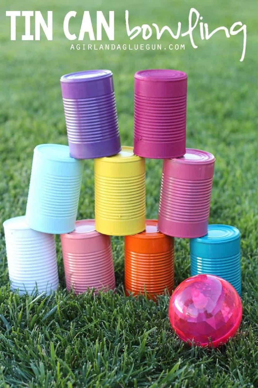 Brightly coloured tin cans and pink ball for DIY bowling alley