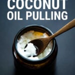 Jar of coconut oil with spoon on dark background