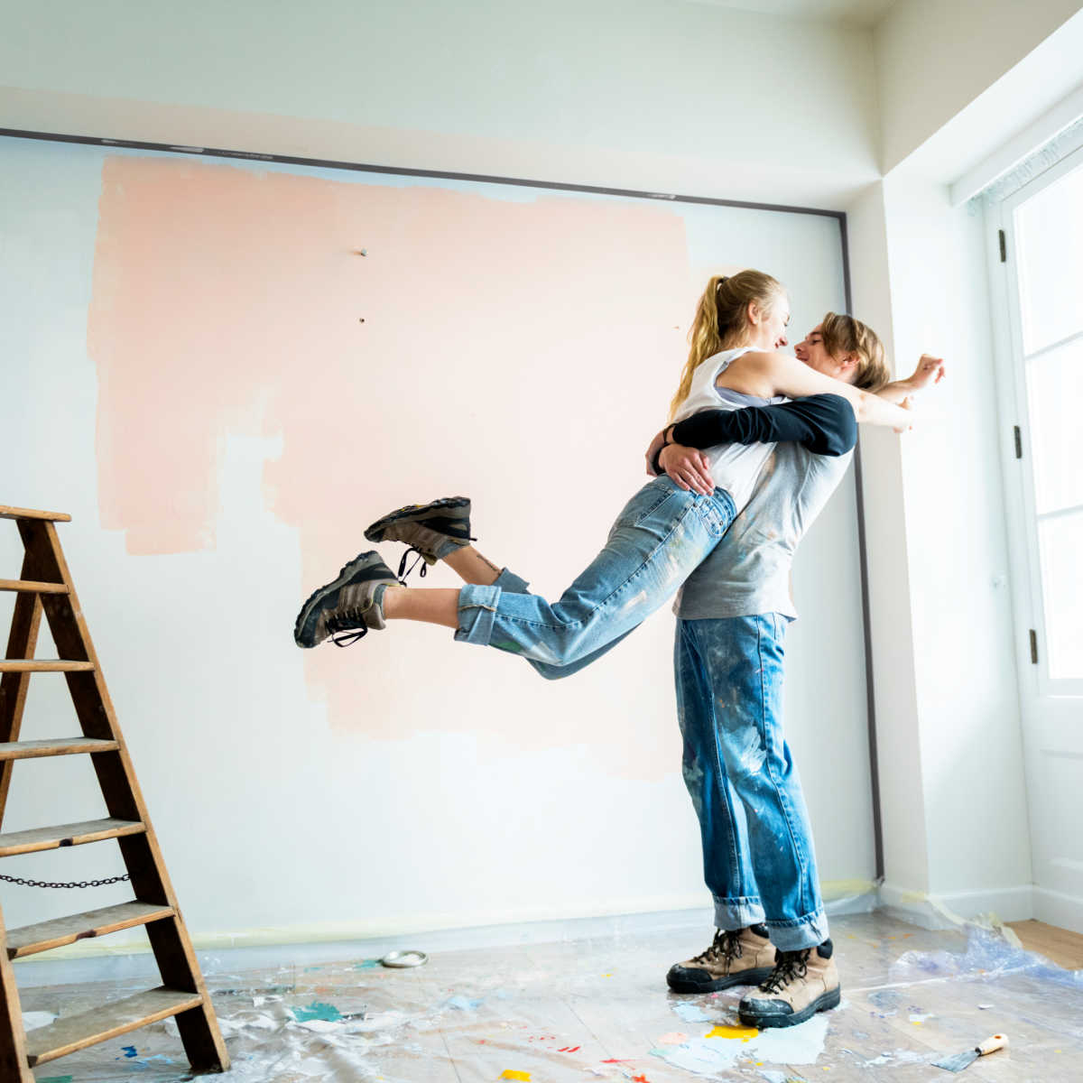 Couple embracing whilst decorating home