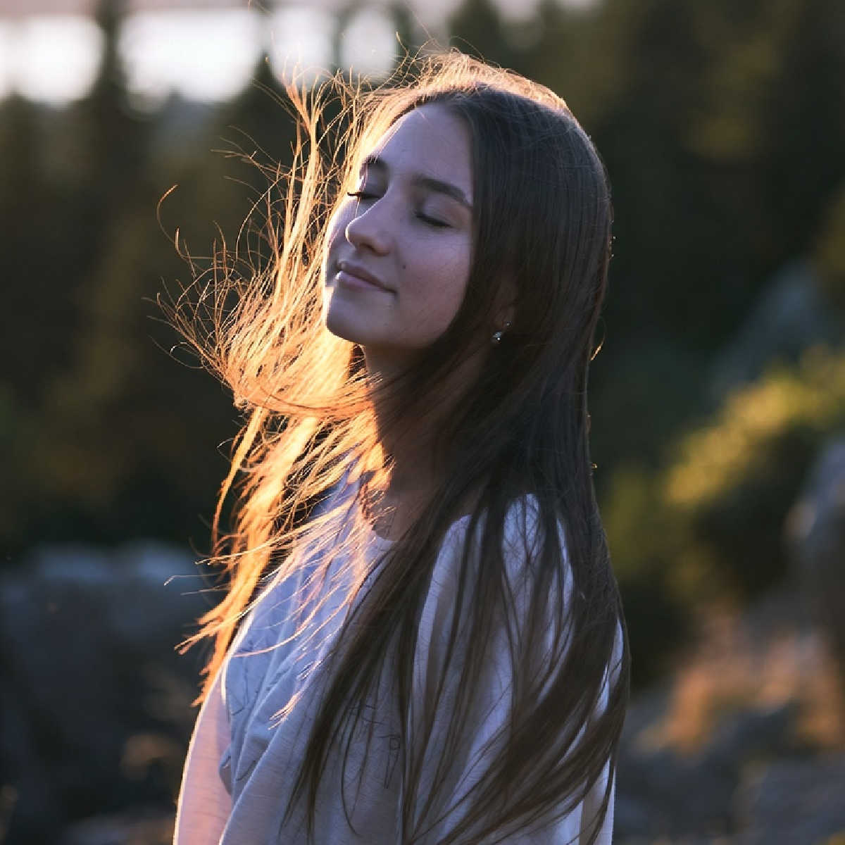 A young woman looking calm and relaxed in the sunset