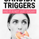 A woman in black and white eating a brightly coloured doughnut