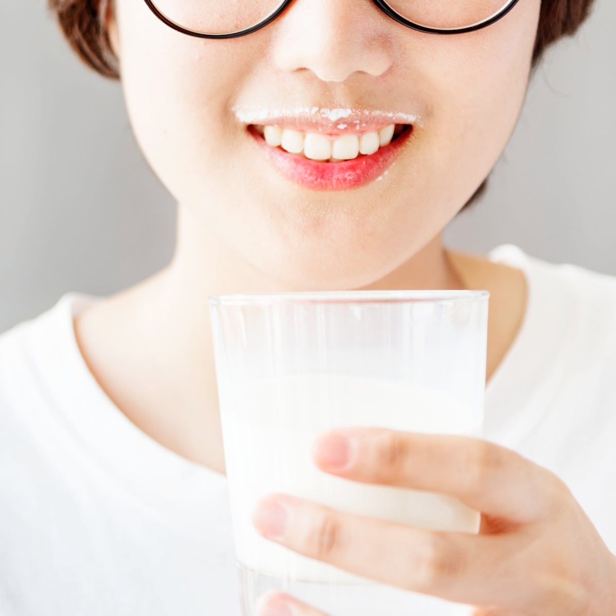 Young woman drinking a glass of milk