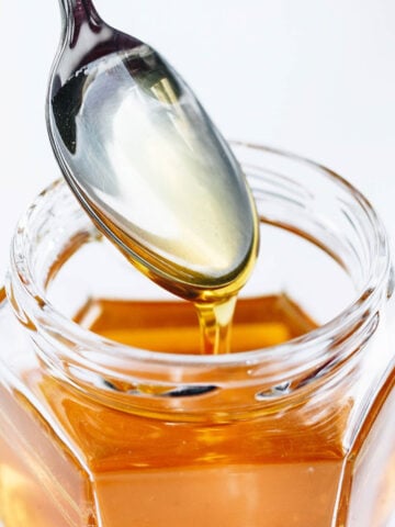 Jar of honey with teaspoon