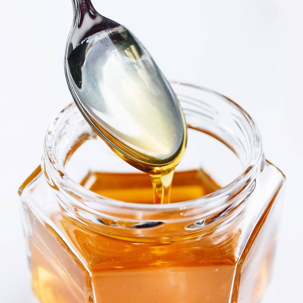 Jar of honey with teaspoon
