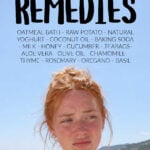 Young woman with ginger hair on beach suffering from sunburn