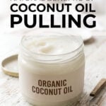 Jar of coconut oil with spoon on worktop